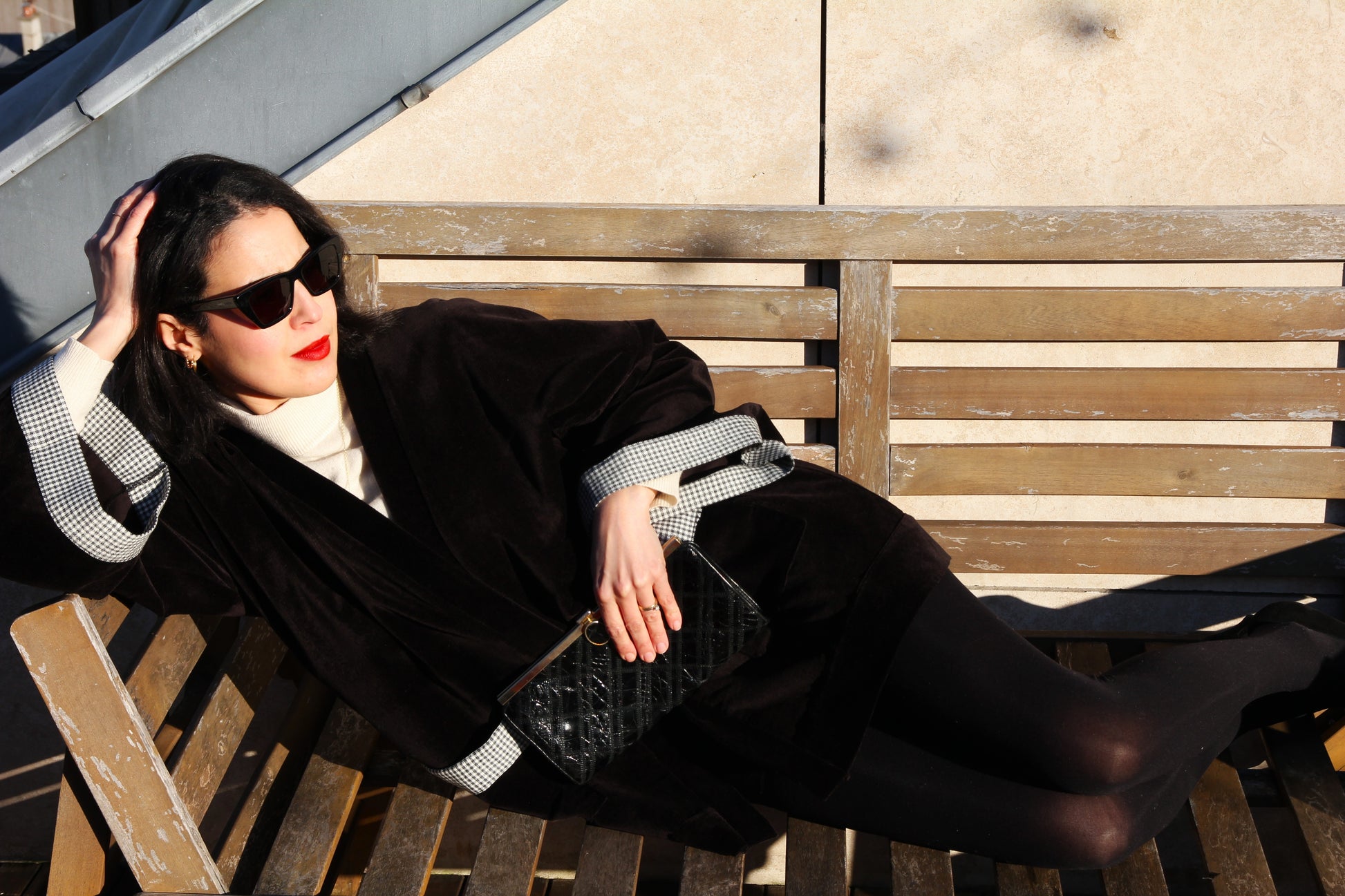 Femme portant élégamment un kimono court en velours côtelé noir et empiècement en laine vichy. L'élégance assumée, le chic décomplexé.