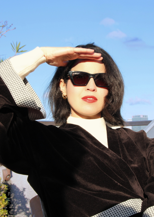 Femme portant élégamment un kimono court en velours côtelé noir et empiècement en laine vichy. L'élégance assumée, le chic décomplexé.