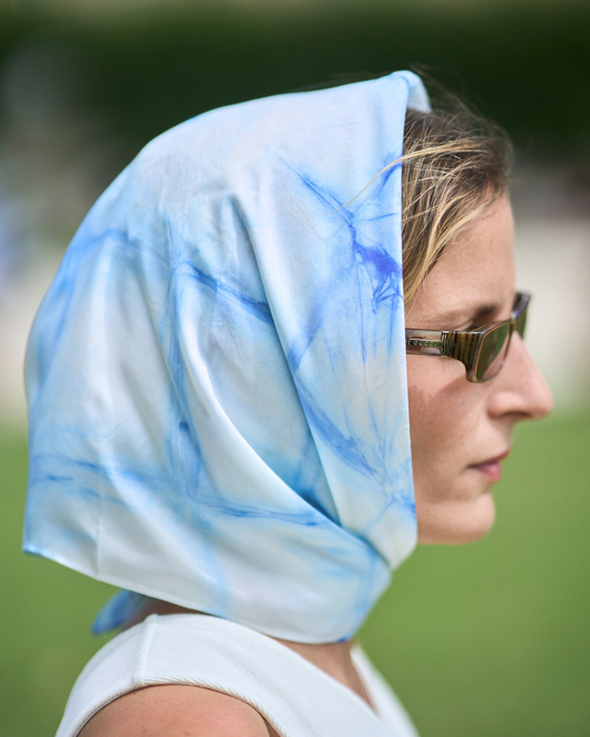 Jeune femme portant un carré en soie noué. Carré en soie 70x70 cm en soie pongé teint à la main à Paris selon la technique Shibori – motif Itajime Carré