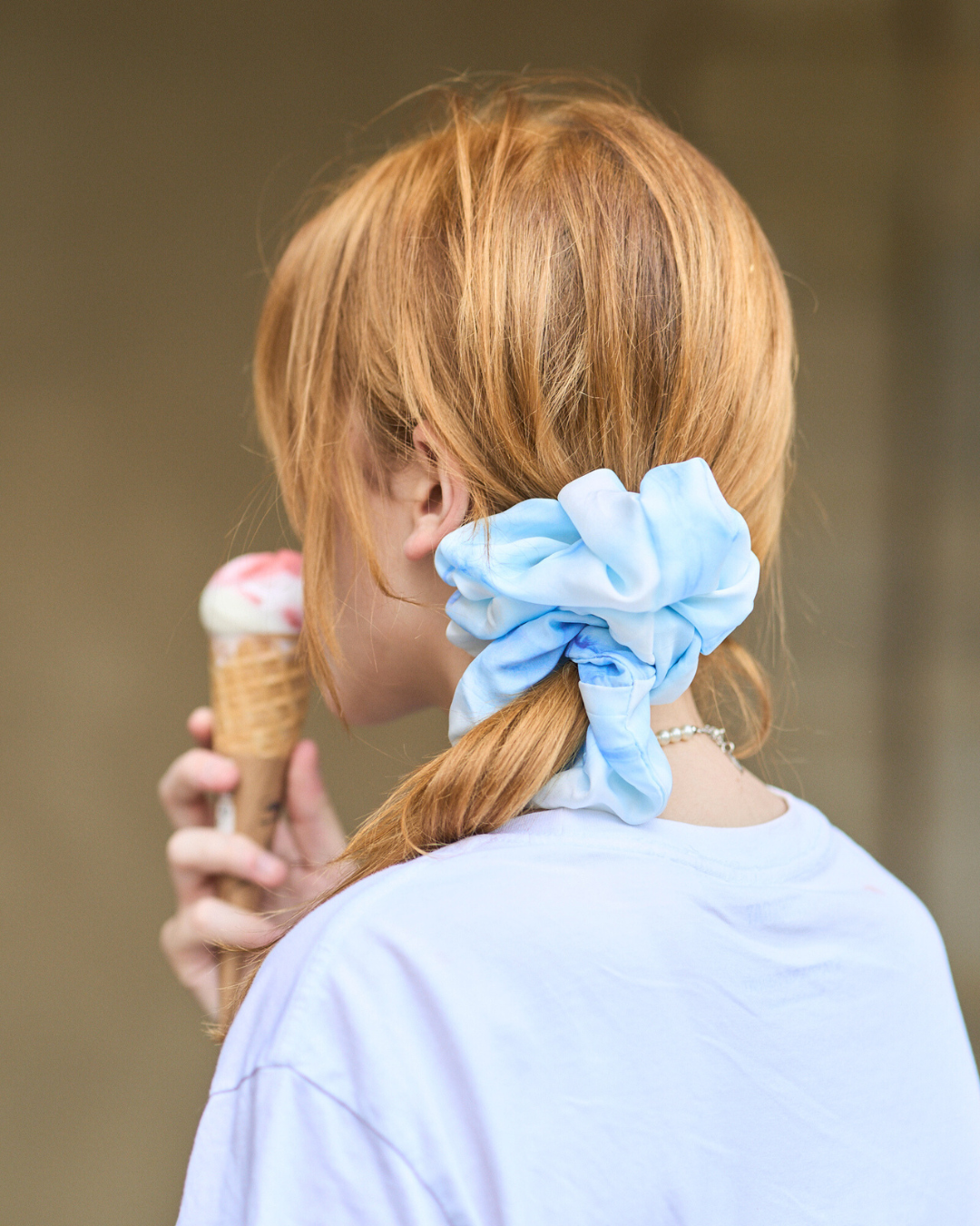 Jeune femme portant un chouchou Maxi en soie pongé teint à la main à Paris selon la technique Shibori – motif Itajime Carré
