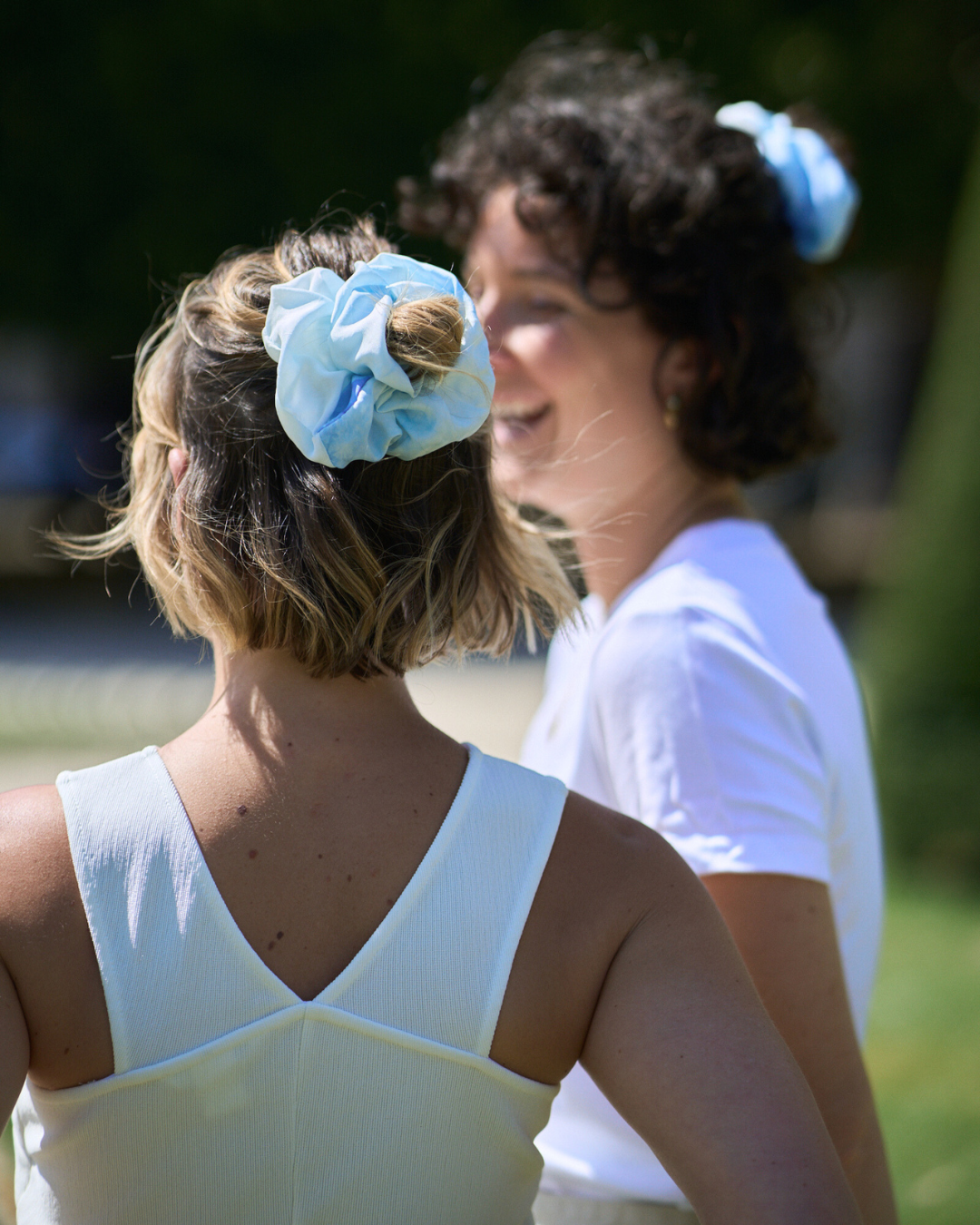 Jeune femme portant un chouchou Regular en soie pongé teint à la main à Paris selon la technique Shibori – motif Itajime Carré