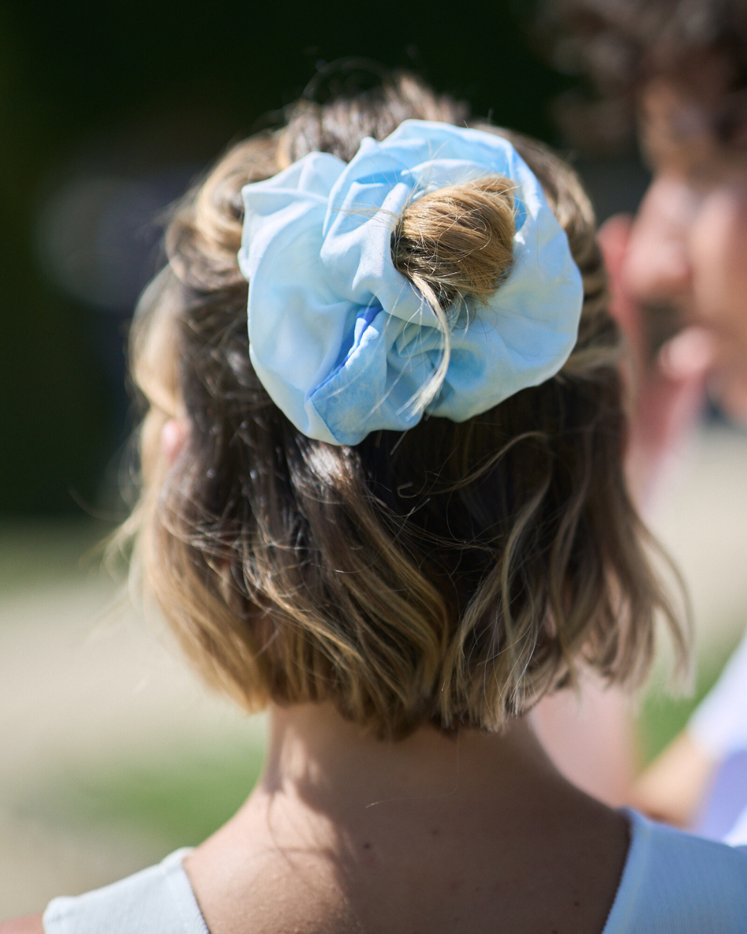 Jeune femme portant un chouchou Regular en soie pongé teint à la main à Paris selon la technique Shibori – motif Itajime Carré