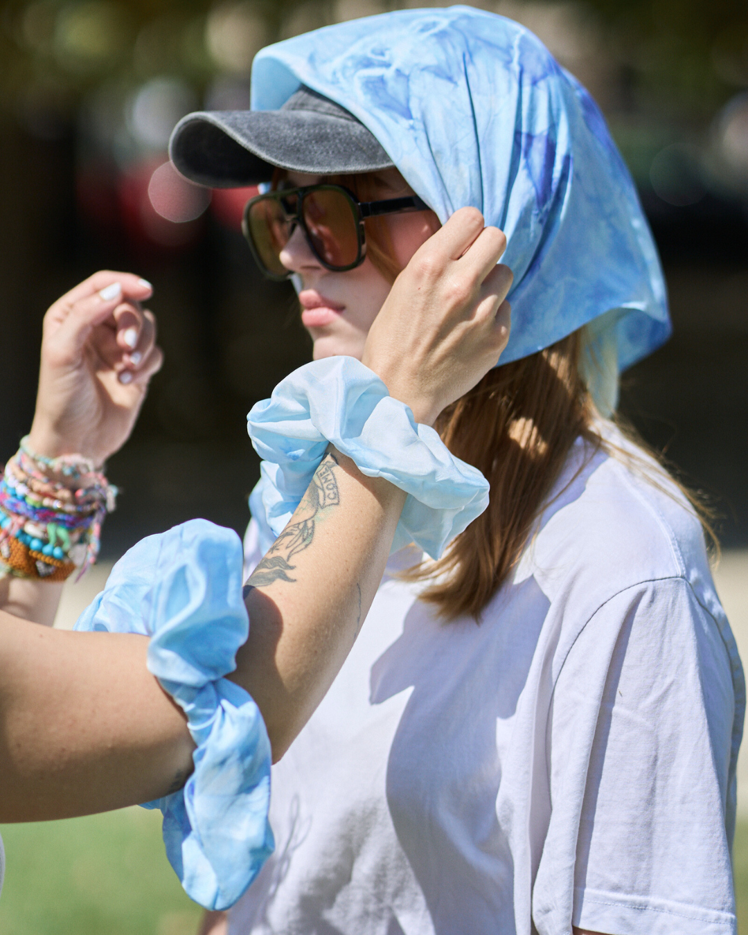 Jeune femme portant un carré en soie 70x70 cm noué en soie pongé teint à la main à Paris selon la technique Shibori – motif Scrunch