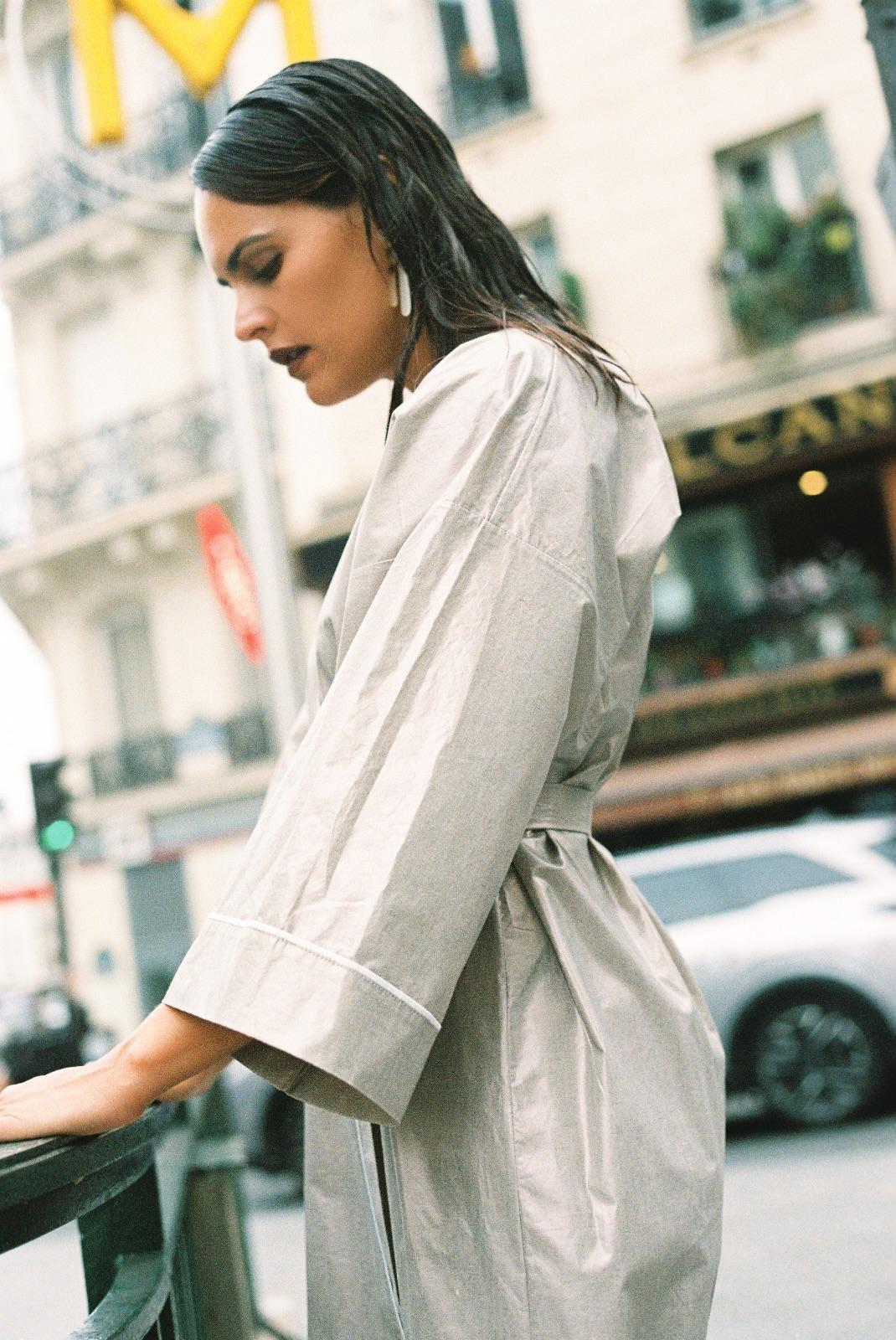 Atelier Sarita – Kimono Crystal en popeline de coton argenté. Long kimono fluide à la coupe affirmée, ceinturé à la taille, confectionné à la main à Paris en série limitée. Une pièce audacieuse et urbaine, inspirée des reflets minéraux et des lumières de l’architecture parisienne.