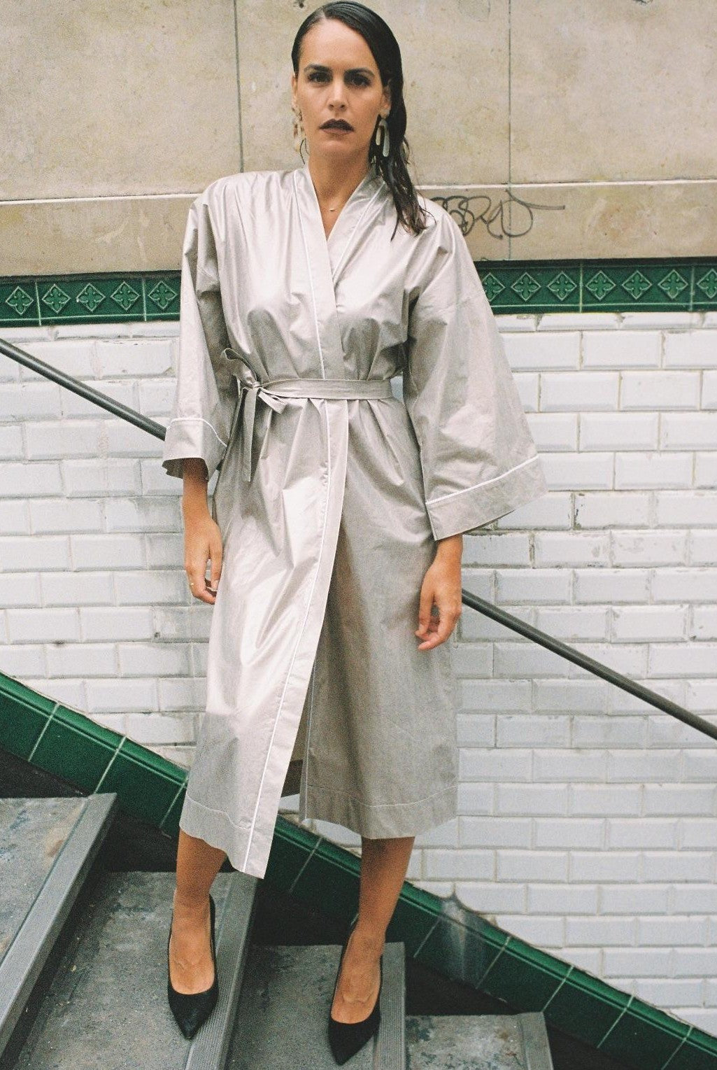 Atelier Sarita – Kimono Crystal en popeline de coton argenté. Long kimono fluide à la coupe affirmée, ceinturé à la taille, confectionné à la main à Paris en série limitée. Une pièce audacieuse et urbaine, inspirée des reflets minéraux et des lumières de l’architecture parisienne.