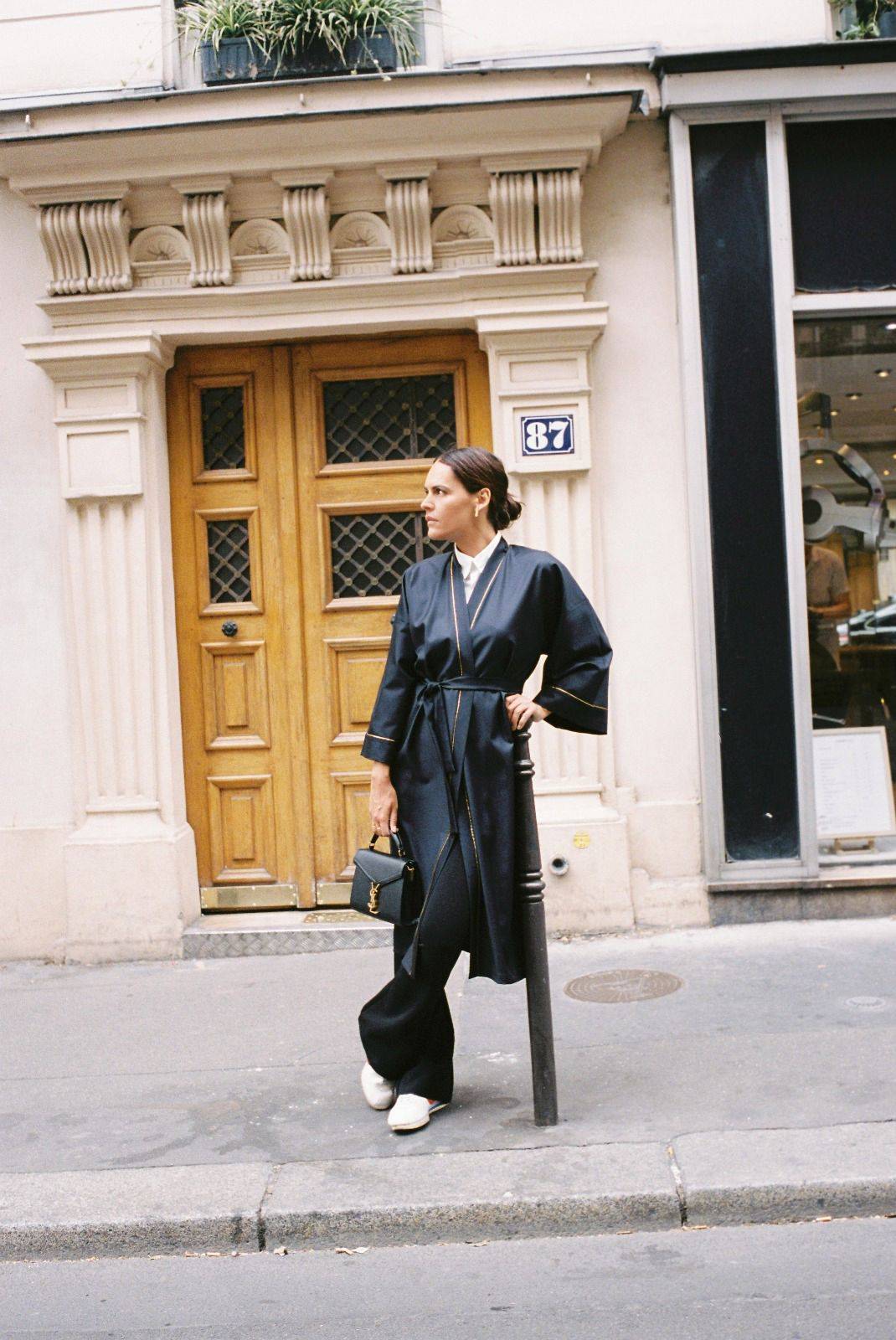Atelier Sarita – Kimono Garnier en laine de costume bleu marine, rehaussé de délicats passepoils en soie dorée. Une coupe longue et fluide, inspirée de l’élégance intemporelle de l’Opéra Garnier, qui incarne la grandeur et la finesse de l’architecture parisienne. Fabriqué à la main à Paris en série très limitée, ce kimono allie la profondeur classique du bleu marine à la lumière subtile de l’or, pour une silhouette sophistiquée et affirmée.