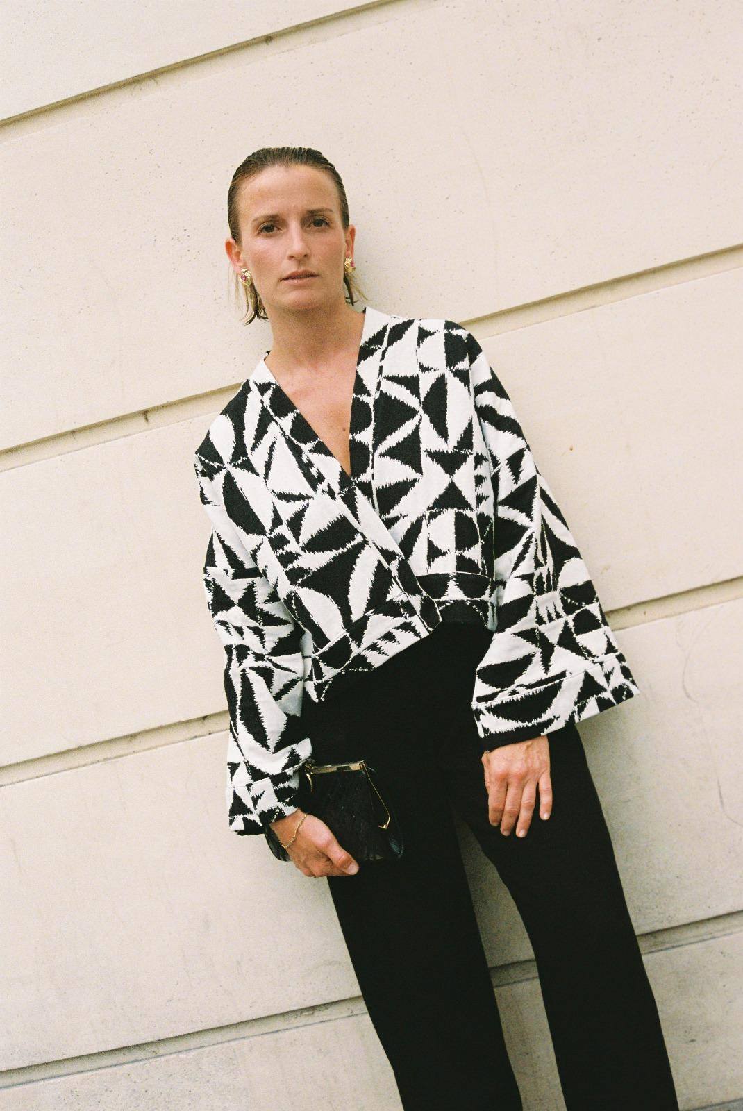 Atelier Sarita – Kimono Kuma en jacquard noir et blanc. Version courte et structurée du kimono, confectionnée à la main à Paris en série limitée. Réalisée dans un jacquard épais mais souple provenant d’une maison de textile française reconnue depuis plus de 200 ans pour son exigence en matière de traçabilité, de production locale et de durabilité. Une pièce audacieuse et graphique, parfaite pour habiller l’automne avec allure.