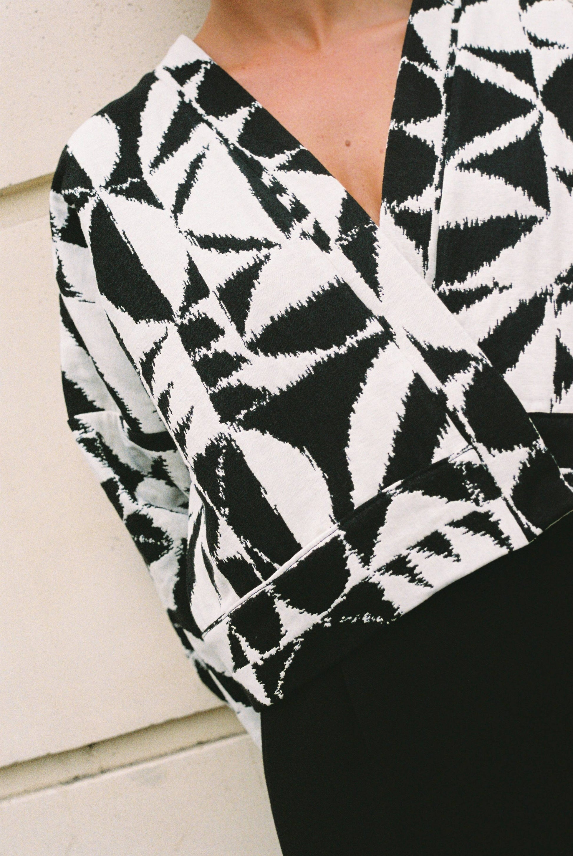Atelier Sarita – Kimono Kuma en jacquard noir et blanc. Version courte et structurée du kimono, confectionnée à la main à Paris en série limitée. Réalisée dans un jacquard épais mais souple provenant d’une maison de textile française reconnue depuis plus de 200 ans pour son exigence en matière de traçabilité, de production locale et de durabilité. Une pièce audacieuse et graphique, parfaite pour habiller l’automne avec allure.