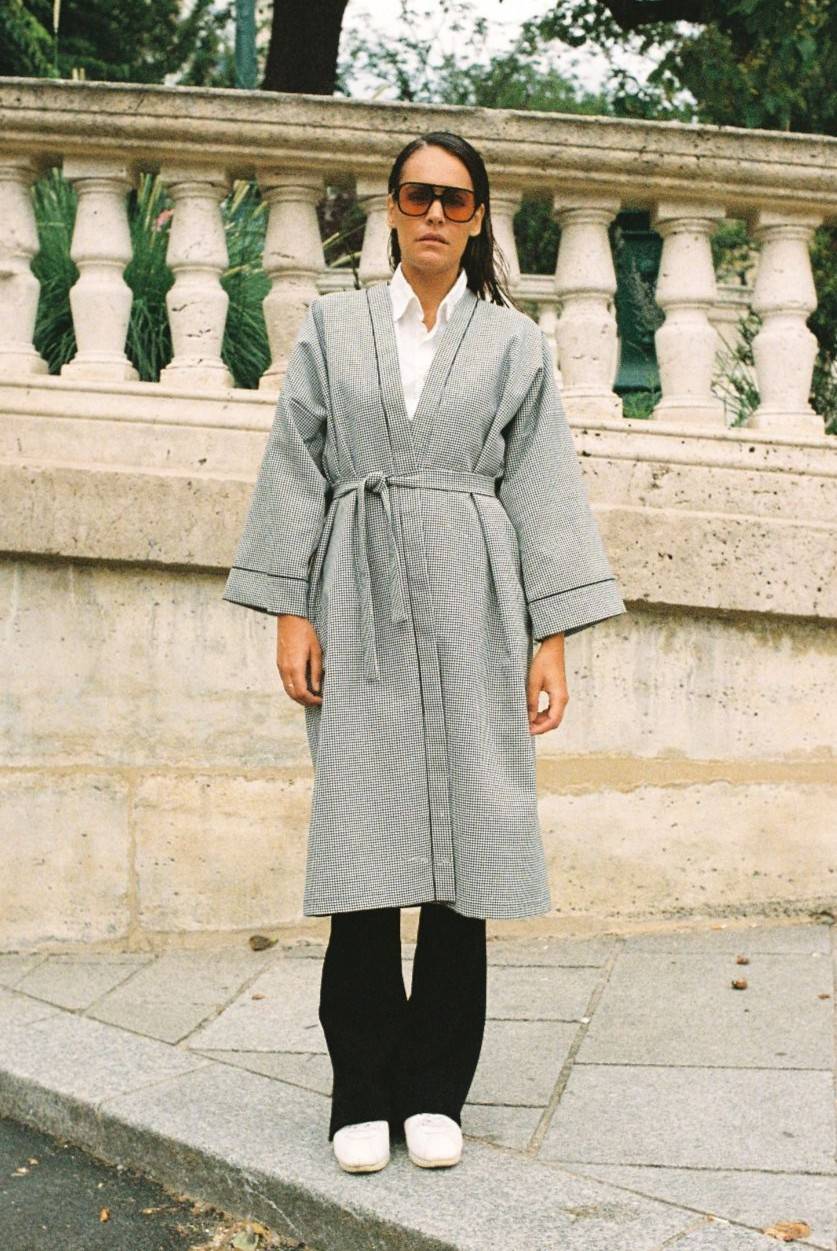 Atelier Sarita – Kimono Mansart en laine de costume pied-de-poule. Long kimono ceinturé à la coupe architecturale, confectionné à la main à Paris en série limitée. Inspiré par la rigueur classique et l’élégance intemporelle, il revisite le tissu tailleur en une pièce urbaine et contemporaine.