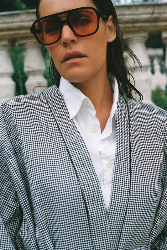 Atelier Sarita – Kimono Mansart en laine de costume pied-de-poule. Long kimono ceinturé à la coupe architecturale, confectionné à la main à Paris en série limitée. Inspiré par la rigueur classique et l’élégance intemporelle, il revisite le tissu tailleur en une pièce urbaine et contemporaine.