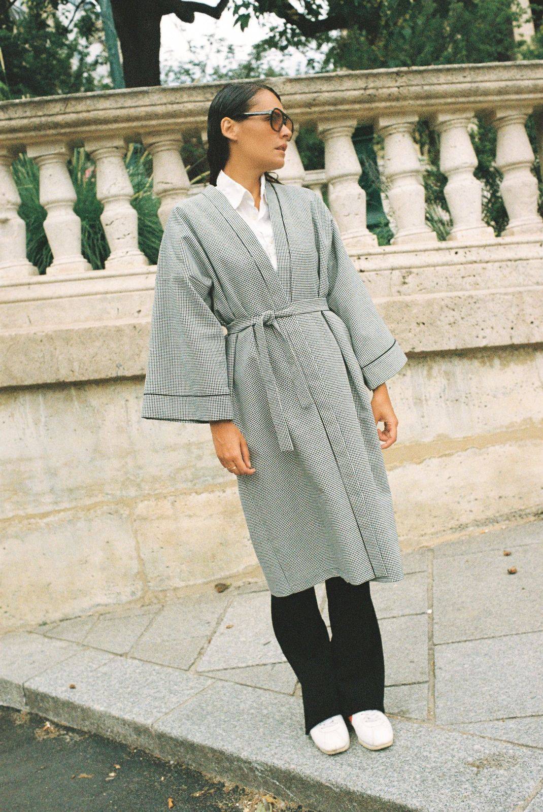 Atelier Sarita – Kimono Mansart en laine de costume pied-de-poule. Long kimono ceinturé à la coupe architecturale, confectionné à la main à Paris en série limitée. Inspiré par la rigueur classique et l’élégance intemporelle, il revisite le tissu tailleur en une pièce urbaine et contemporaine.