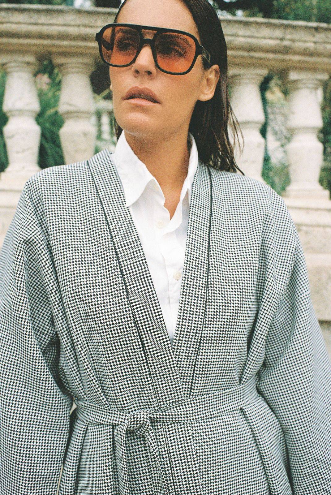 Atelier Sarita – Kimono Mansart en laine de costume pied-de-poule. Long kimono ceinturé à la coupe architecturale, confectionné à la main à Paris en série limitée. Inspiré par la rigueur classique et l’élégance intemporelle, il revisite le tissu tailleur en une pièce urbaine et contemporaine.