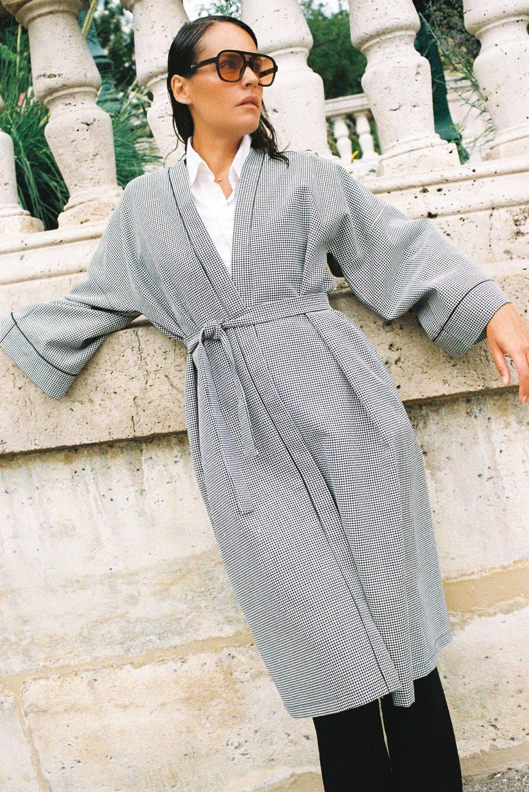 Atelier Sarita – Kimono Mansart en laine de costume pied-de-poule. Long kimono ceinturé à la coupe architecturale, confectionné à la main à Paris en série limitée. Inspiré par la rigueur classique et l’élégance intemporelle, il revisite le tissu tailleur en une pièce urbaine et contemporaine.