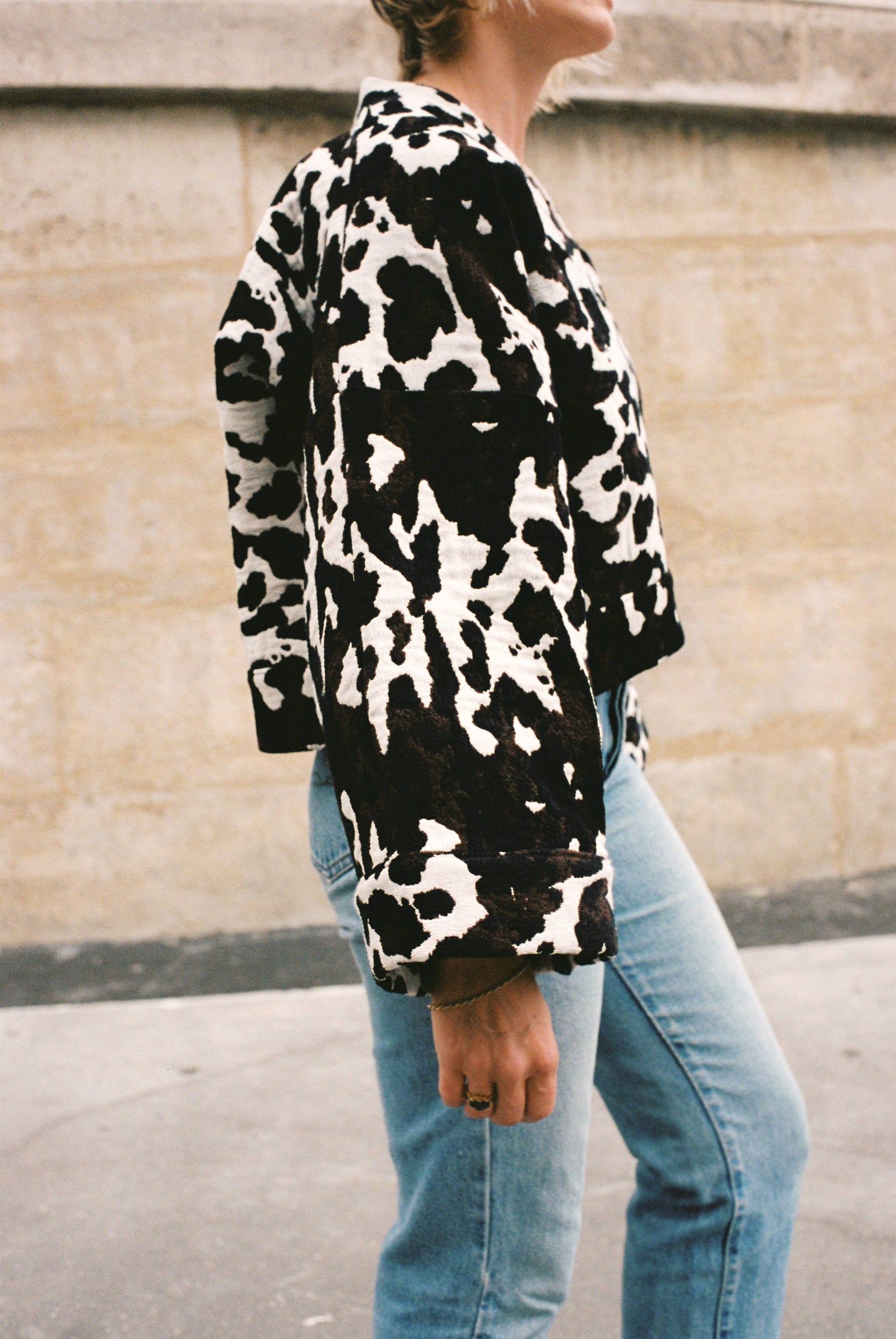 Atelier Sarita – Kimono Roger en jacquard motif vache. Une coupe courte et audacieuse, pensée comme une pièce arty et urbaine, qui bouscule les codes du vestiaire parisien. Confectionné à la main à Paris en série limitée, ce kimono est réalisé dans un jacquard épais et texturé, issu d’une maison textile française reconnue pour son savoir-faire et son exigence en matière de durabilité. Une pièce singulière qui célèbre l’originalité et le mouvement urbain.