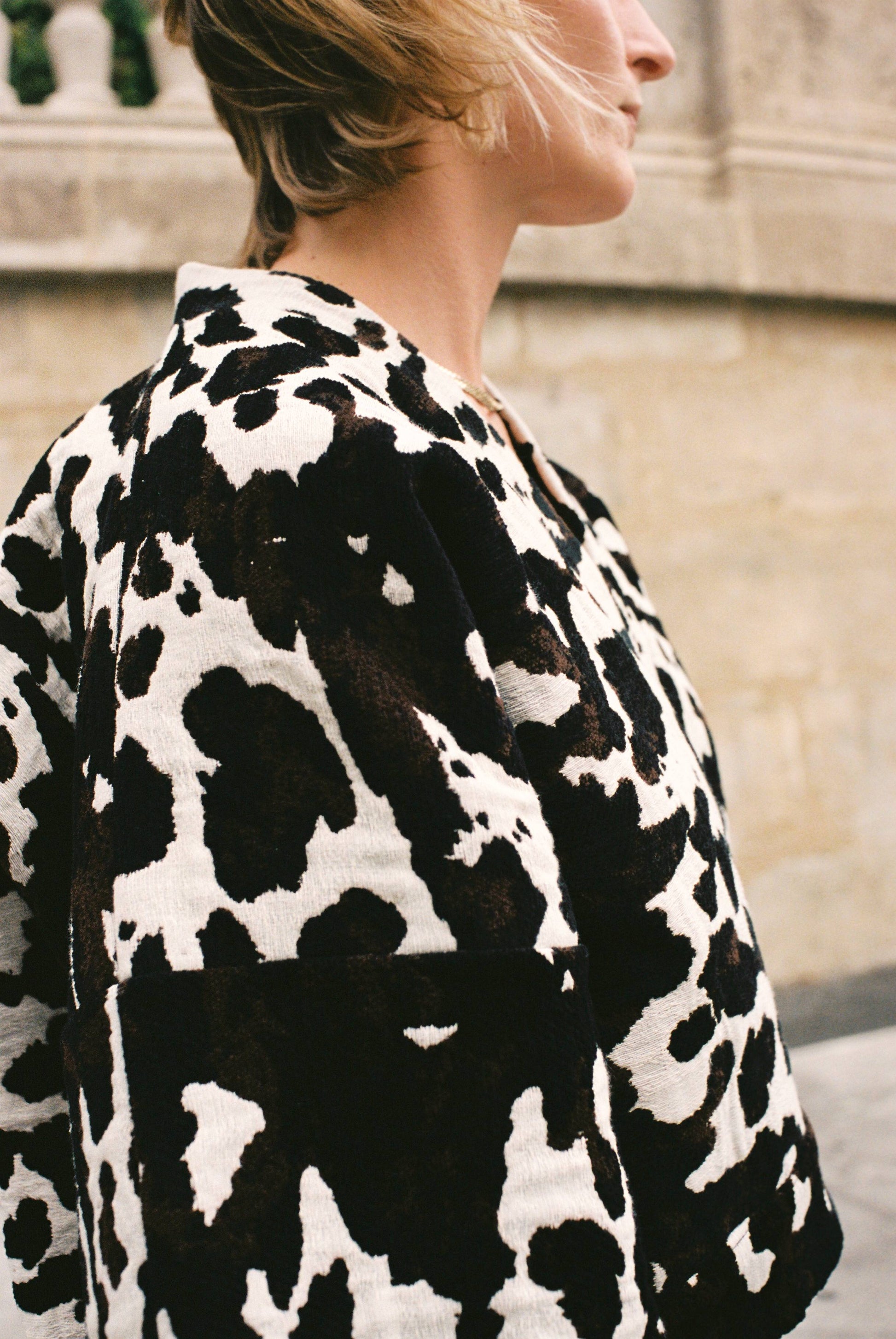 Atelier Sarita – Kimono Roger en jacquard motif vache. Une coupe courte et audacieuse, pensée comme une pièce arty et urbaine, qui bouscule les codes du vestiaire parisien. Confectionné à la main à Paris en série limitée, ce kimono est réalisé dans un jacquard épais et texturé, issu d’une maison textile française reconnue pour son savoir-faire et son exigence en matière de durabilité. Une pièce singulière qui célèbre l’originalité et le mouvement urbain.