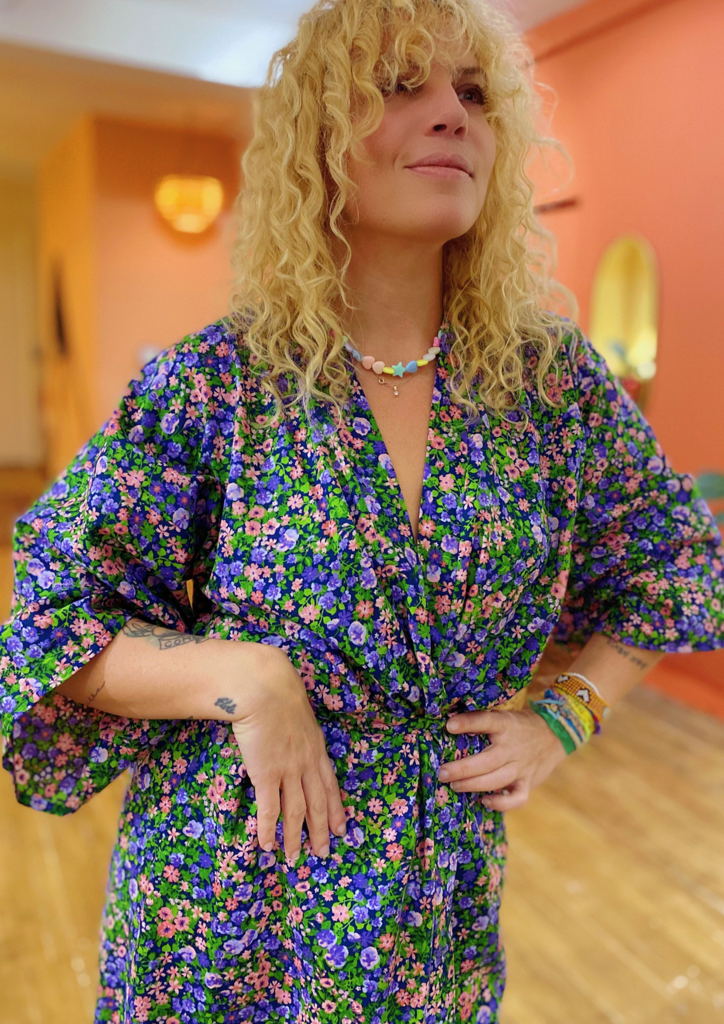 Femme portant un kimono long en coton à motifs floraux colorés, coupe ample et manches larges.