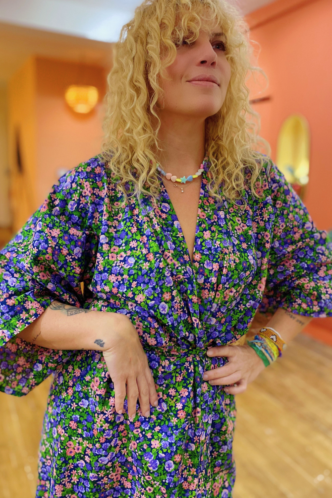 Femme portant un kimono long en coton à motifs floraux colorés, coupe ample et manches larges.