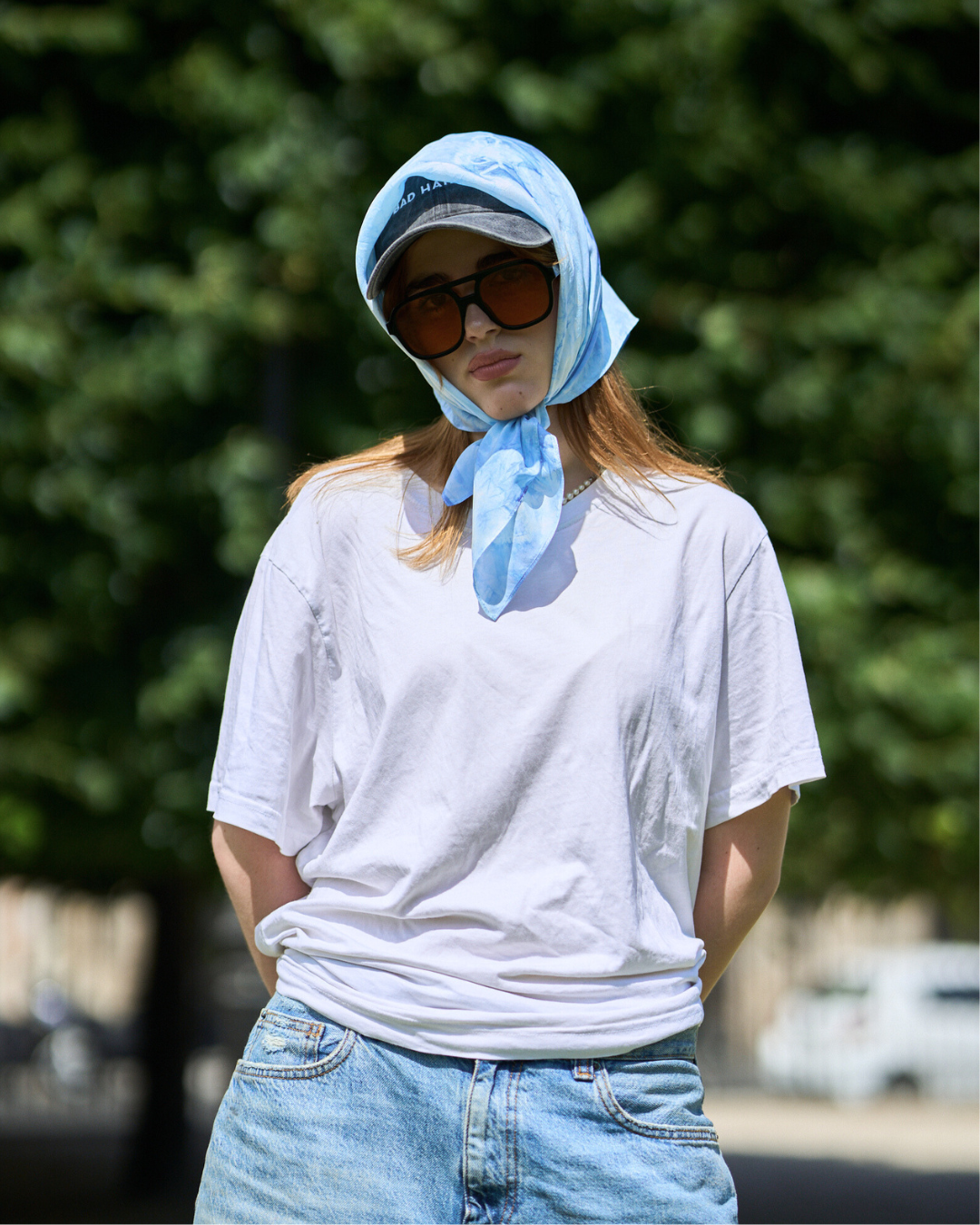 Jeune femme portant un carré en soie 70x70 cm noué en soie pongé teint à la main à Paris selon la technique Shibori – motif Scrunch