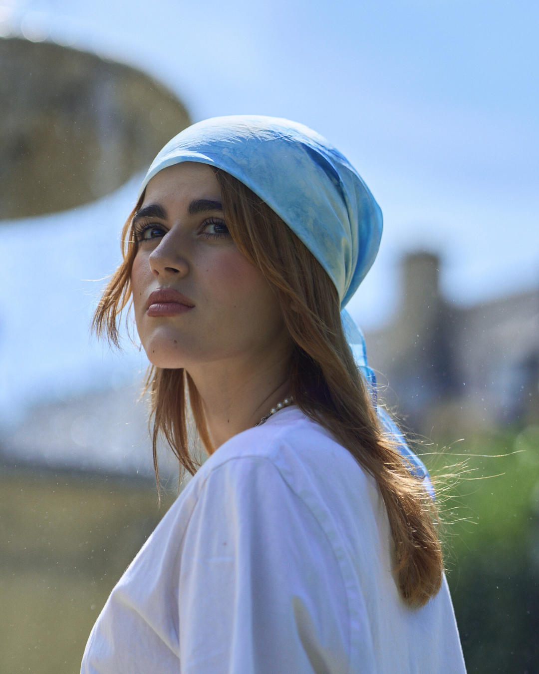 Jeune femme portant un carré en soie 70x70 cm noué en soie pongé teint à la main à Paris selon la technique Shibori – motif Scrunch