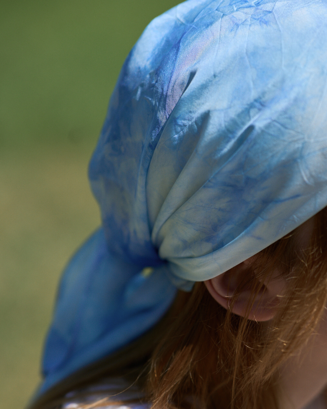Jeune femme portant un carré en soie 70x70 cm noué en soie pongé teint à la main à Paris selon la technique Shibori – motif Scrunch