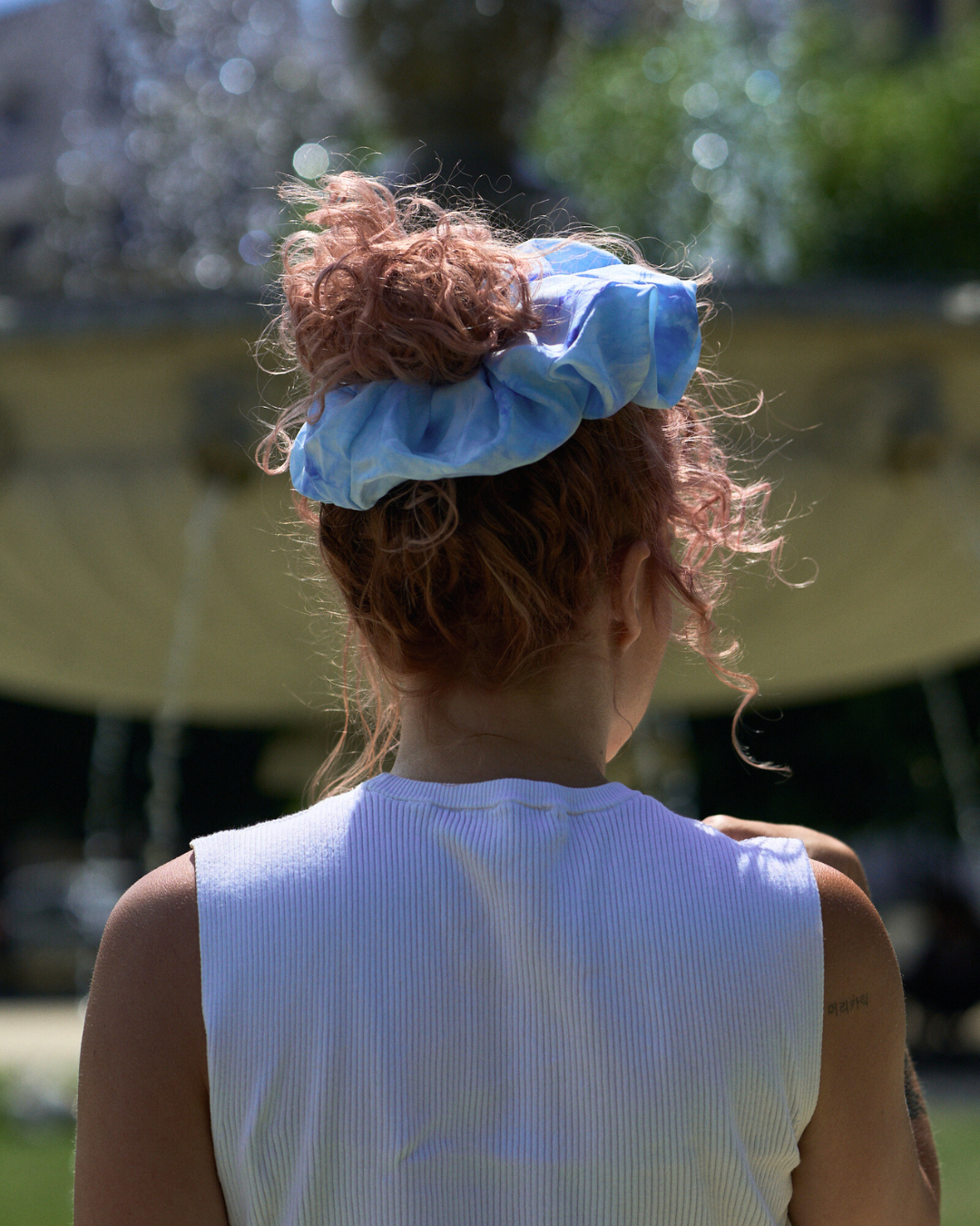Jeune femme portant un chouchou Maxi en soie pongé teint à la main à Paris selon la technique Shibori – motif Scrunch