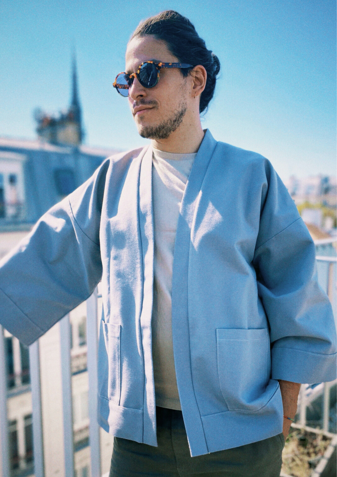 Homme portant un kimono gris en coton biologique, coupe ample avec ceinture. Pièce confectionnée à la main à Paris, par Atelier Sarita.