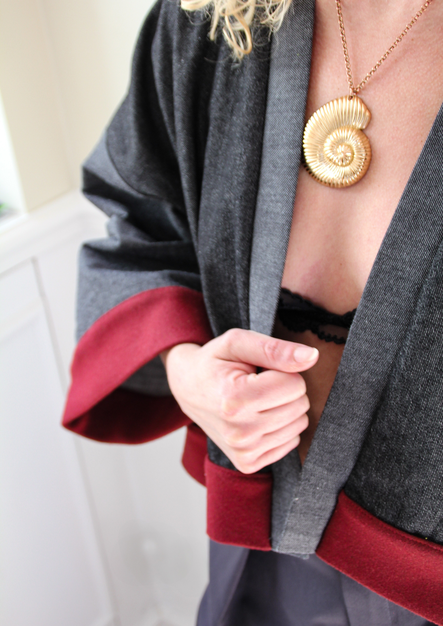 Cardigan kimono en denim noir et gris avec finitions en laine bordeaux et poches, coupe ample et style épuré.