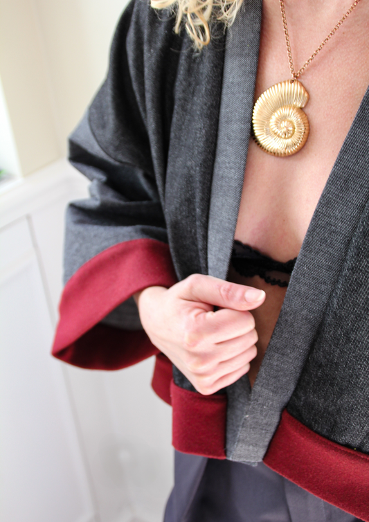 Cardigan kimono en denim noir et gris avec finitions en laine bordeaux et poches, coupe ample et style épuré.