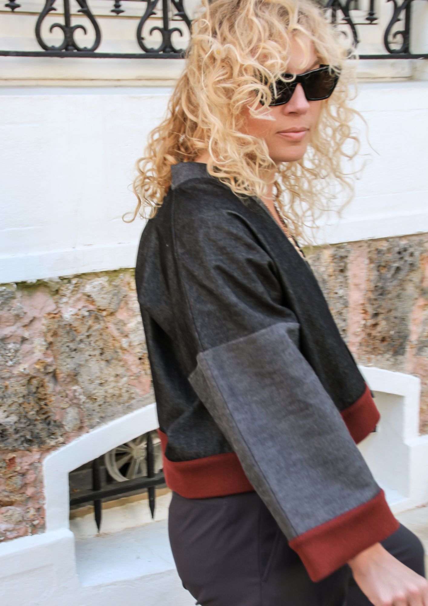 Cardigan kimono en denim noir et gris avec finitions en laine bordeaux et poches, coupe ample et style épuré.