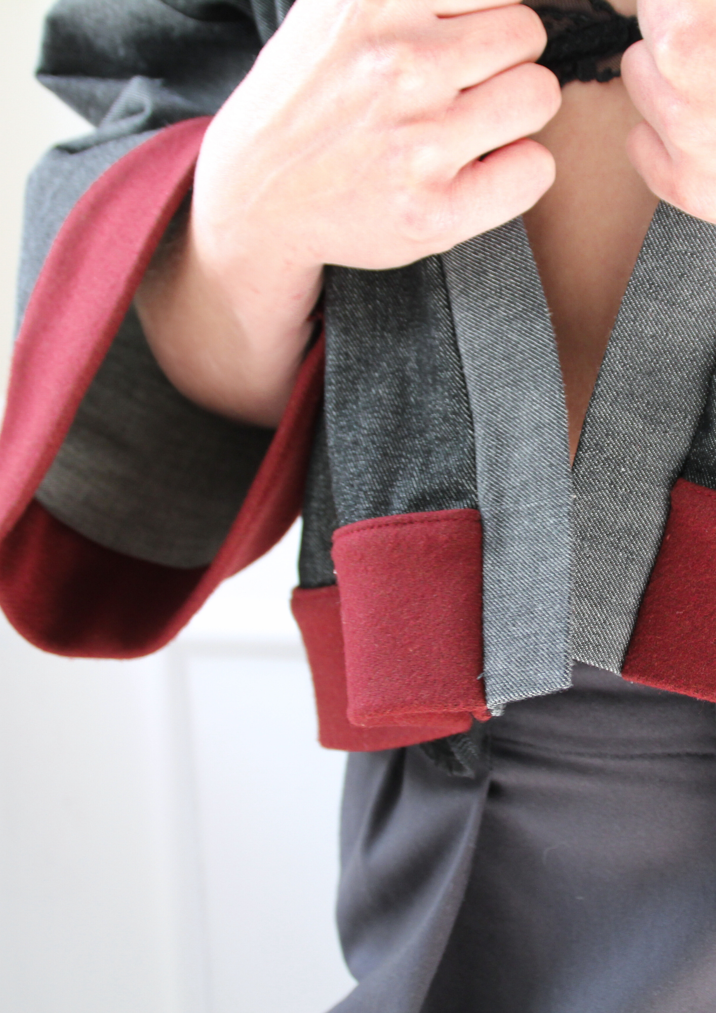 Cardigan kimono en denim noir et gris avec finitions en laine bordeaux et poches, coupe ample et style épuré.