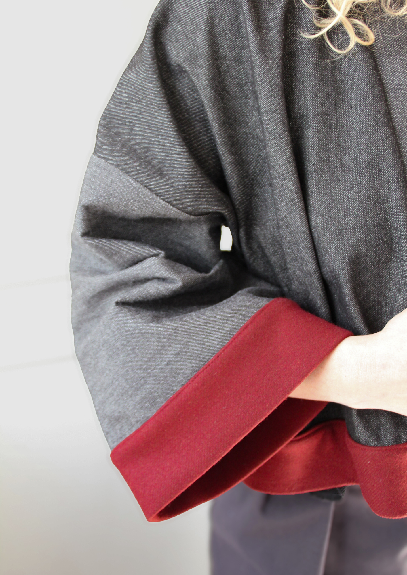 Cardigan kimono en denim noir et gris avec finitions en laine bordeaux et poches, coupe ample et style épuré.