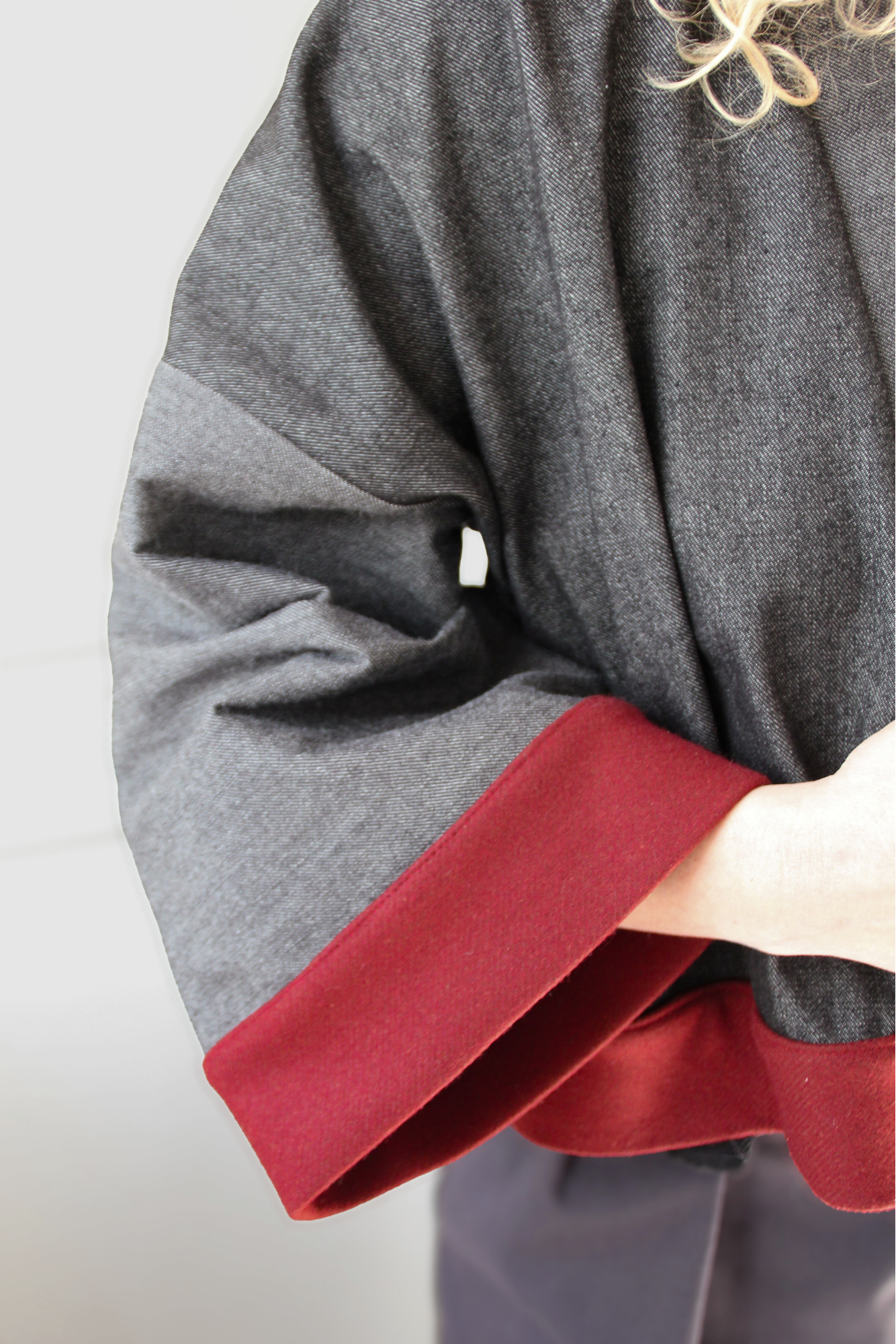 Cardigan kimono en denim noir et gris avec finitions en laine bordeaux et poches, coupe ample et style épuré.