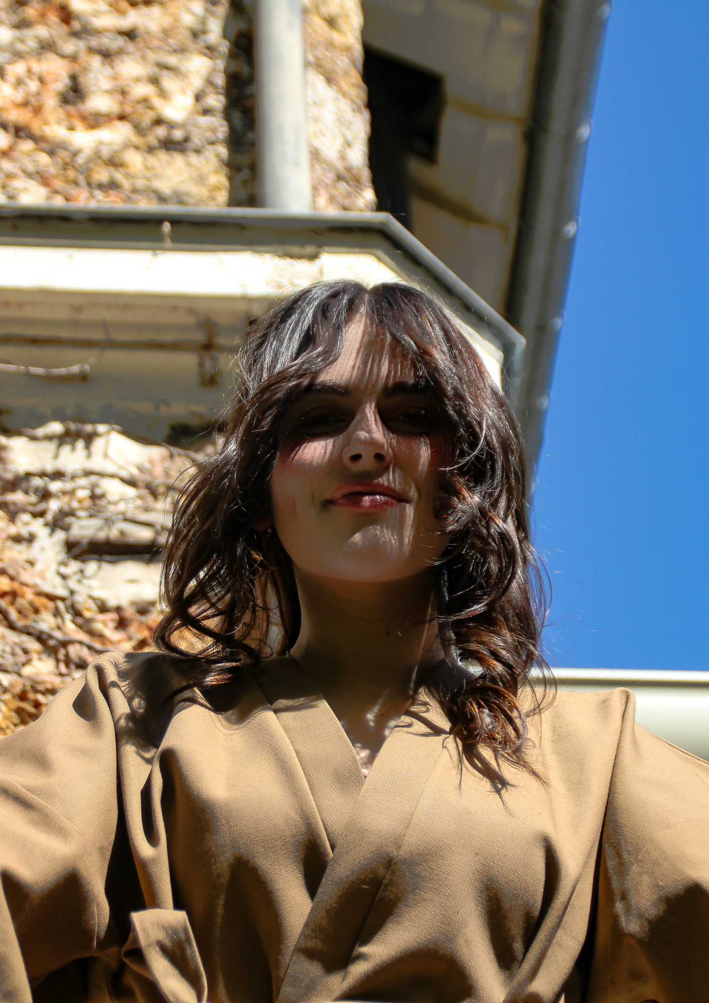 Femme portant un kimono court en bachette de coton bio marron, coupe ample avec poches plaquées et finitions soignées, conçu dans une démarche d’upcycling.