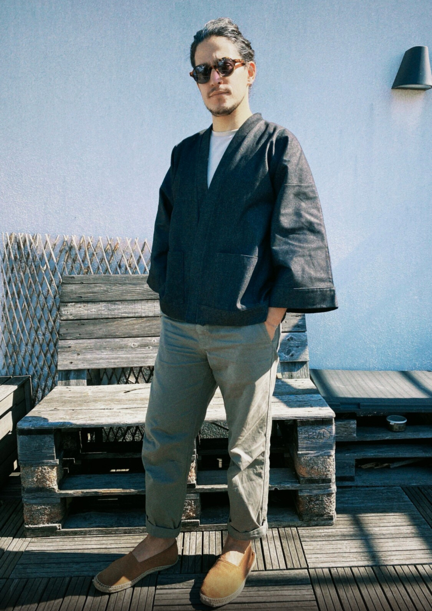 Homme portant un kimono court en denim noir 100% coton, avec manches larges et poches plaquées, fait à la main à Paris.