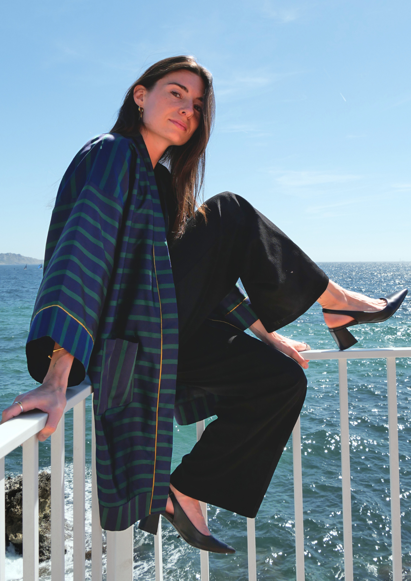 Femme portant un kimono mi-long en soie bleu et vert rehaussé d’un liseré doré, modèle Atelier Sarita fait main à Paris.