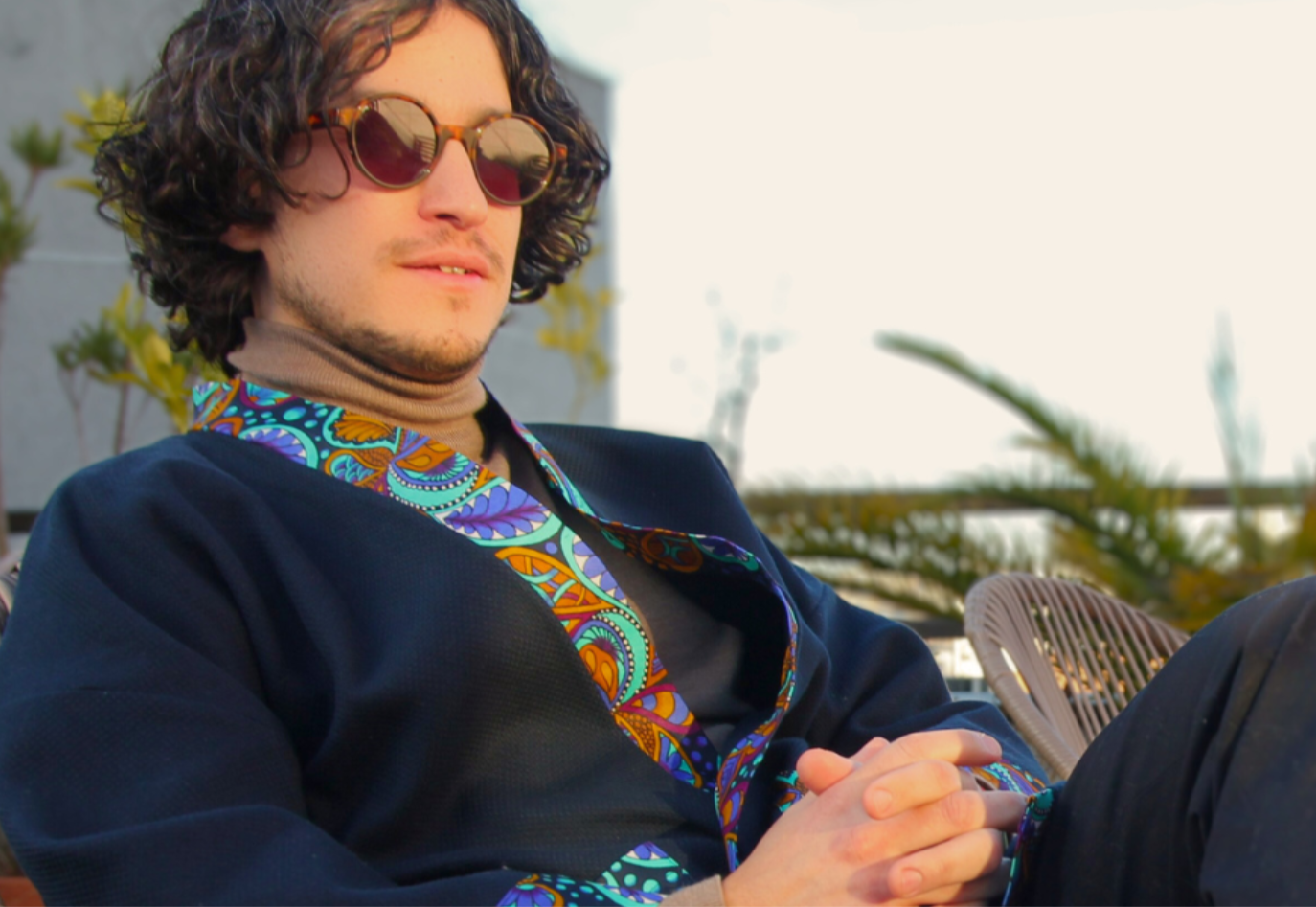 Homme portant un kimono court en coton bleu avec finitions en wax coloré, manches larges et poches assorties.