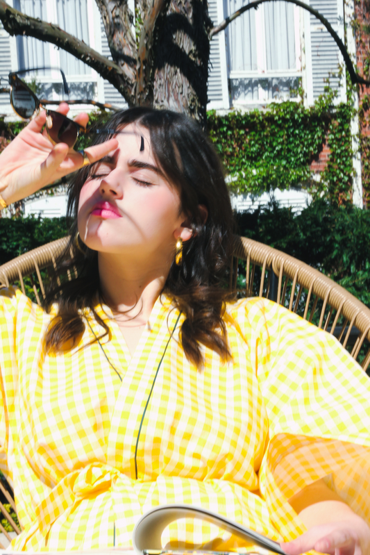 Femme portant un kimono court en coton vichy jaune à passepoil vert, noué à la taille.