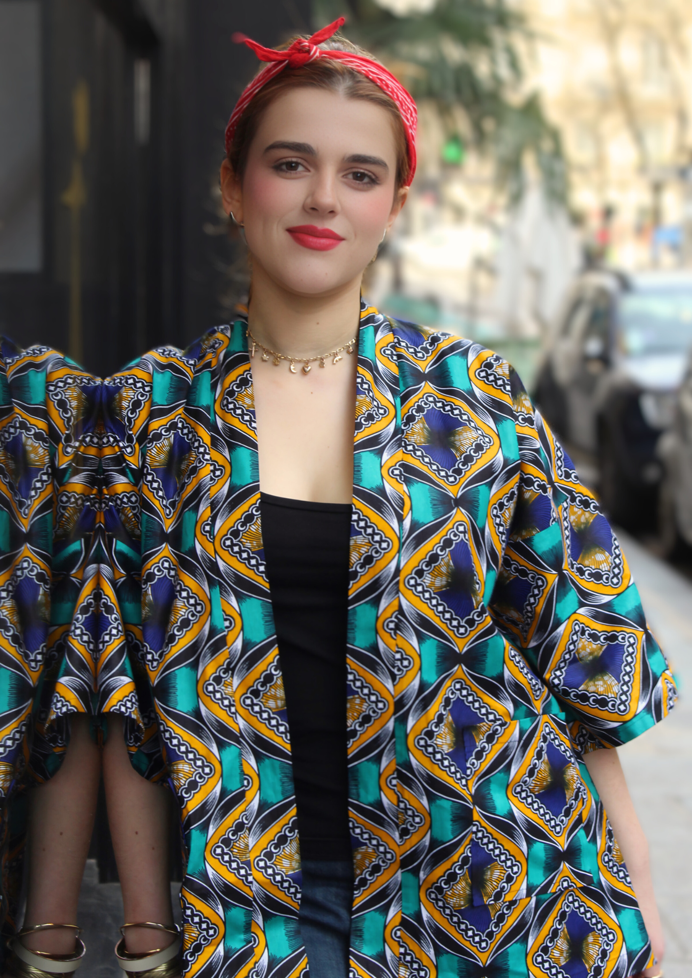 Jeune femme vêtue d'un kimono en wax lifestyle, avec la ceinture du kimono nouée dans les cheveux.