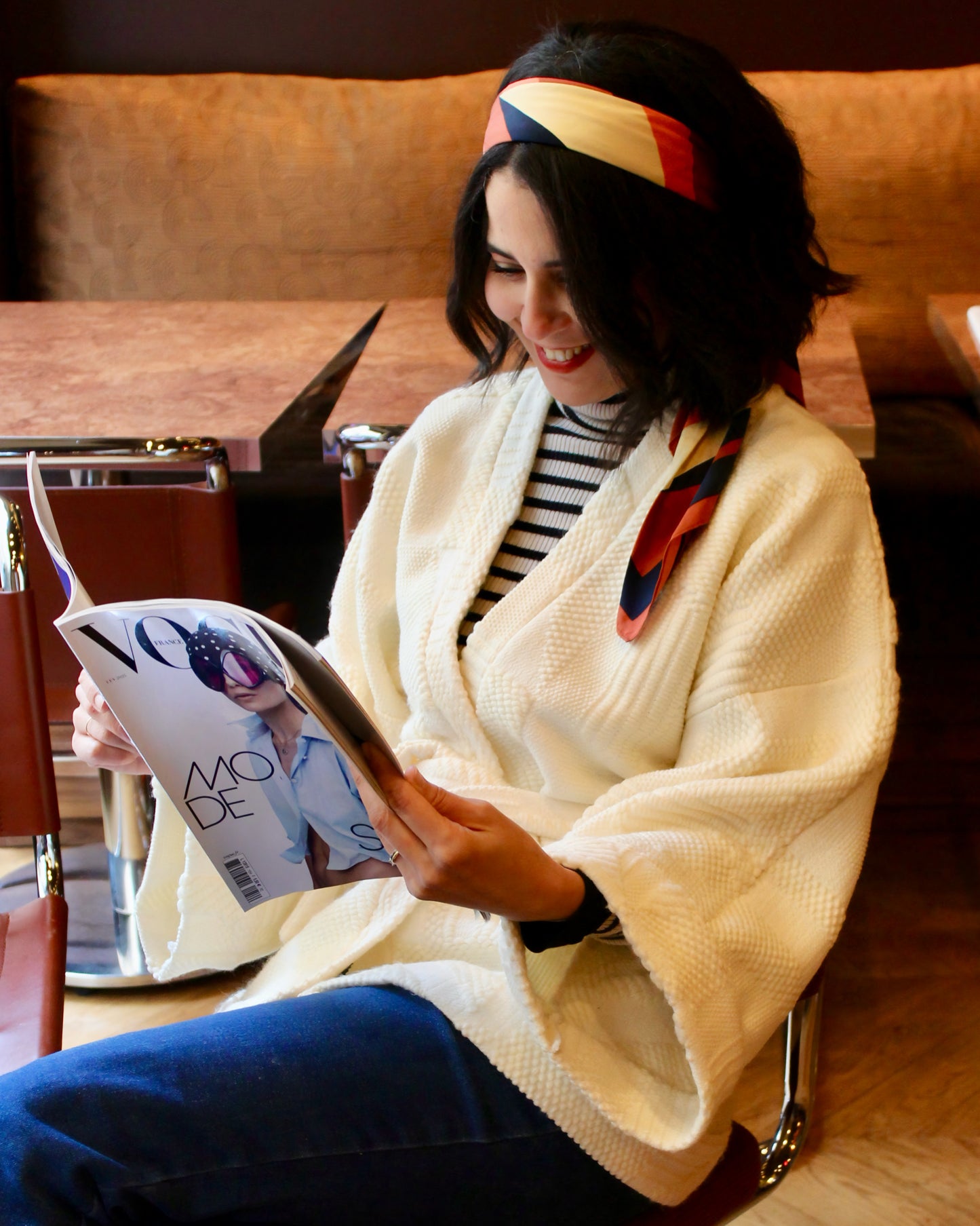Jeune femme au look retro porte un kimono en laine blanc cassé, doux et élégant, idéal pour les douces journées printanières. Cette pièce unique est confectionnée à la main avec soin à Paris.