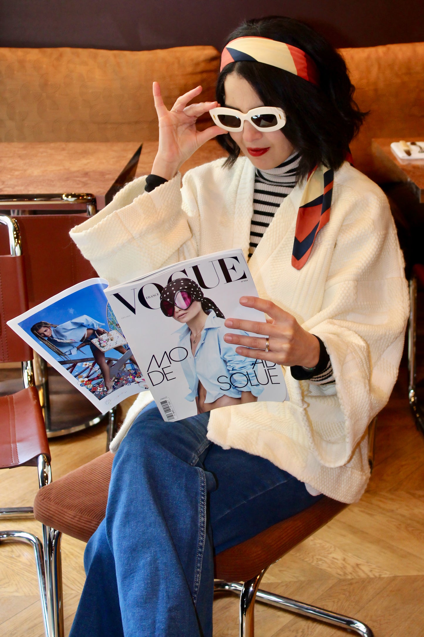 Jeune femme au look retro porte un kimono en laine blanc cassé, doux et élégant, idéal pour les douces journées printanières. Cette pièce unique est confectionnée à la main avec soin à Paris.