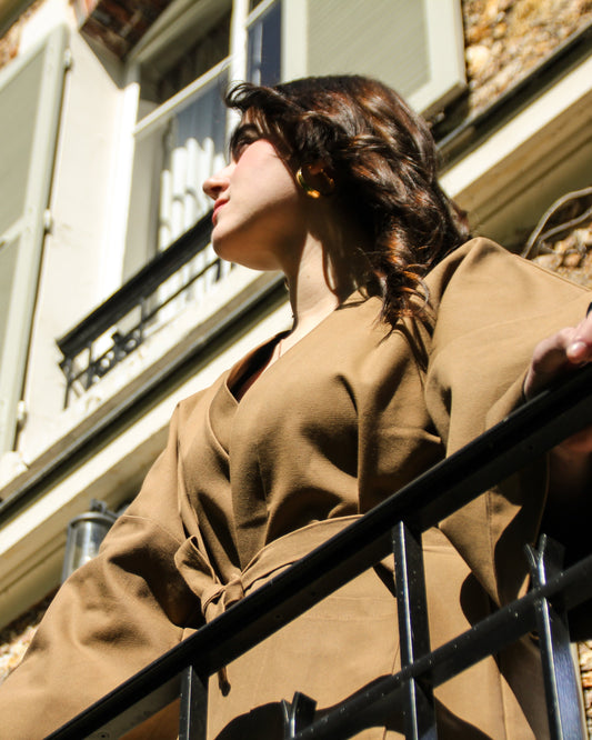 Femme portant un kimono court en bachette de coton bio marron, coupe ample avec poches plaquées et finitions soignées, conçu dans une démarche d’upcycling.