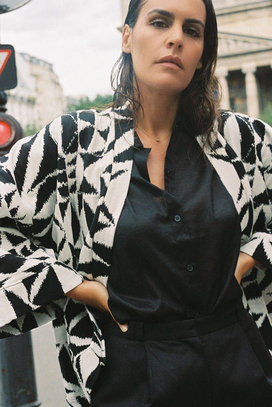 Atelier Sarita – Kimono Ito en jacquard noir et blanc. Une coupe ample et enveloppante, pensée pour épouser le mouvement urbain avec assurance et élégance. Confectionné à la main à Paris en série limitée, ce modèle est réalisé dans un jacquard graphique épais mais souple, provenant d’une maison de textile française fondée il y a plus de 200 ans et reconnue pour son exigence en matière de traçabilité, de production locale et de durabilité. Une pièce forte et audacieuse, parfaite pour l’automne.