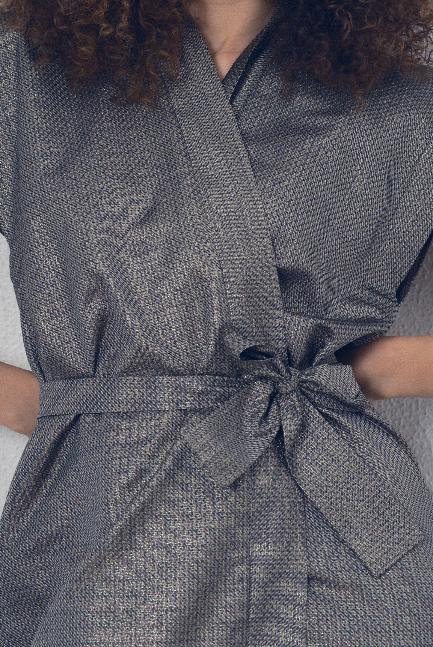 Robe portefeuille en soie lamée gris foncé portée ceinturée, modèle Barbette de la collection Côté Marais par Atelier Sarita