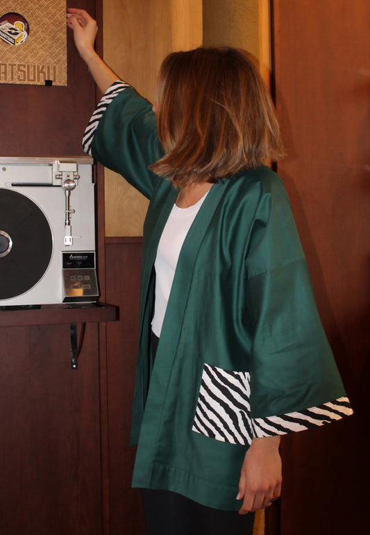 Kimono en coton vert avec poches et revers de manches au motif zèbre, confectionné à la main à Paris. Pièce unique, coupe ample et fluide, idéale pour un look chic et décontracté.
