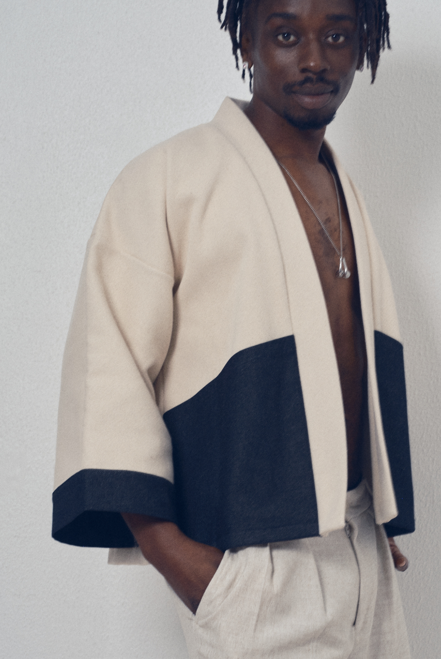 Veste courte écrue et denim noir aux lignes kimono portée avec un pantalon clair, modèle Simon de la collection Côté Marais par Atelier Sarita.