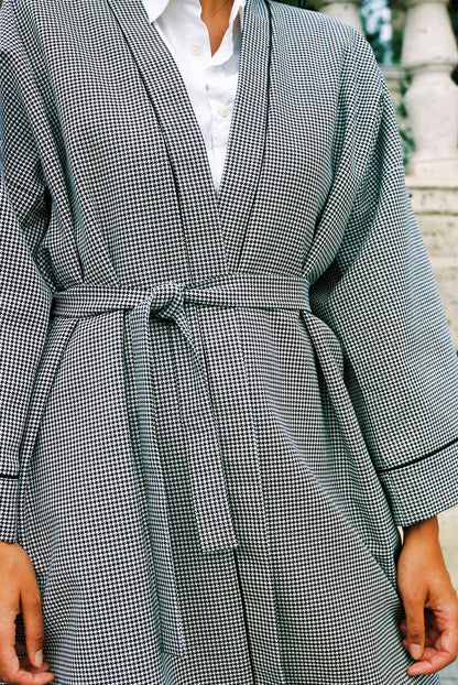 Atelier Sarita – Kimono Mansart en laine de costume pied-de-poule. Long kimono ceinturé à la coupe architecturale, confectionné à la main à Paris en série limitée. Inspiré par la rigueur classique et l’élégance intemporelle, il revisite le tissu tailleur en une pièce urbaine et contemporaine.