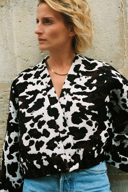 Atelier Sarita – Kimono Roger en jacquard motif vache. Une coupe courte et audacieuse, pensée comme une pièce arty et urbaine, qui bouscule les codes du vestiaire parisien. Confectionné à la main à Paris en série limitée, ce kimono est réalisé dans un jacquard épais et texturé, issu d’une maison textile française reconnue pour son savoir-faire et son exigence en matière de durabilité. Une pièce singulière qui célèbre l’originalité et le mouvement urbain.