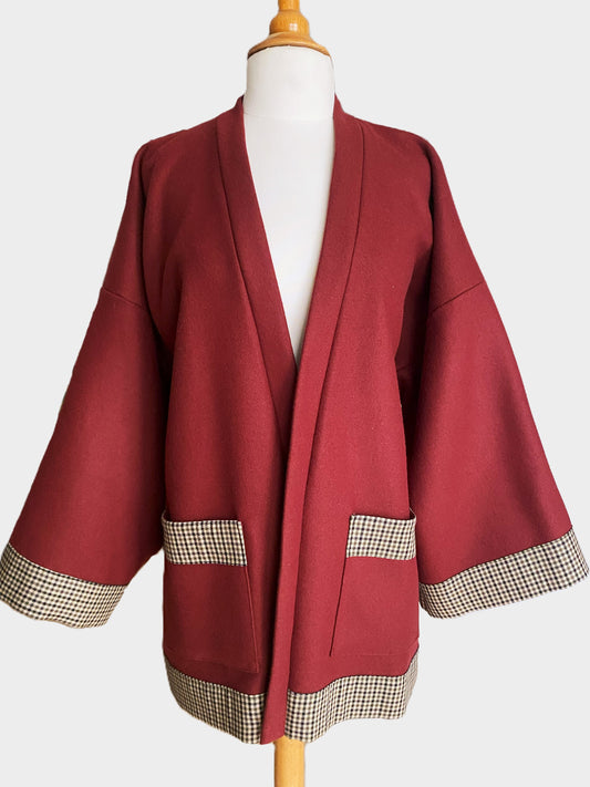 Kimono en laine bordeaux avec finitions pied-de-poule, manches larges et poches, présenté sur un mannequin.