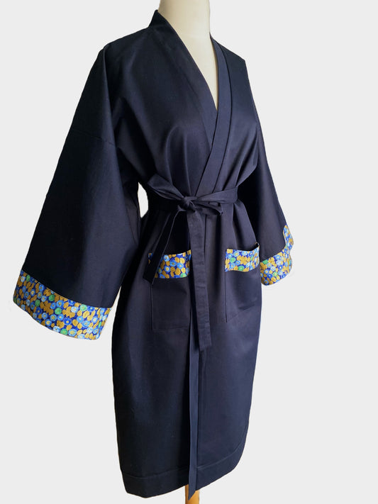 Kimono bleu avec finitions colorées sur les manches et les poches, présenté sur un mannequin. Fabrication artisanale à Paris.