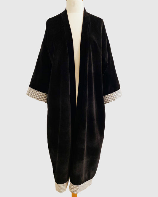 Kimono long en velours noir avec détails vichy aux poignets et à l'ourlet, coupe fluide et manches larges, présenté sur un mannequin.